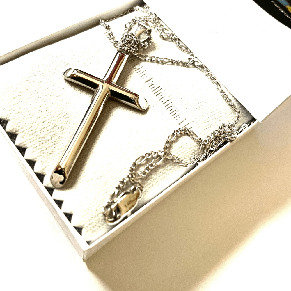 Silver cross pendant necklace displayed in a gift box with soft lining, showcasing elegant craftsmanship.