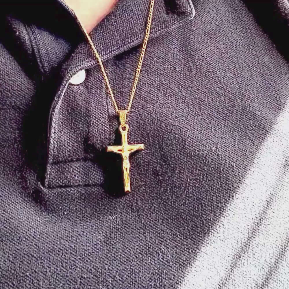 24k yellow gold filled crucifix necklace worn on a black polo shirt, showcasing intricate design and craftsmanship.